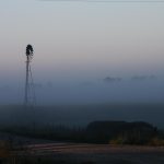 Windmill shrouded in fog at a farm outside of Walker, Iowa